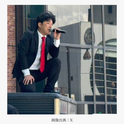 電話ボックスに上がり、乙武洋匡さん・小池百合子さんの街頭演説にかぶせて演説する黒川さん